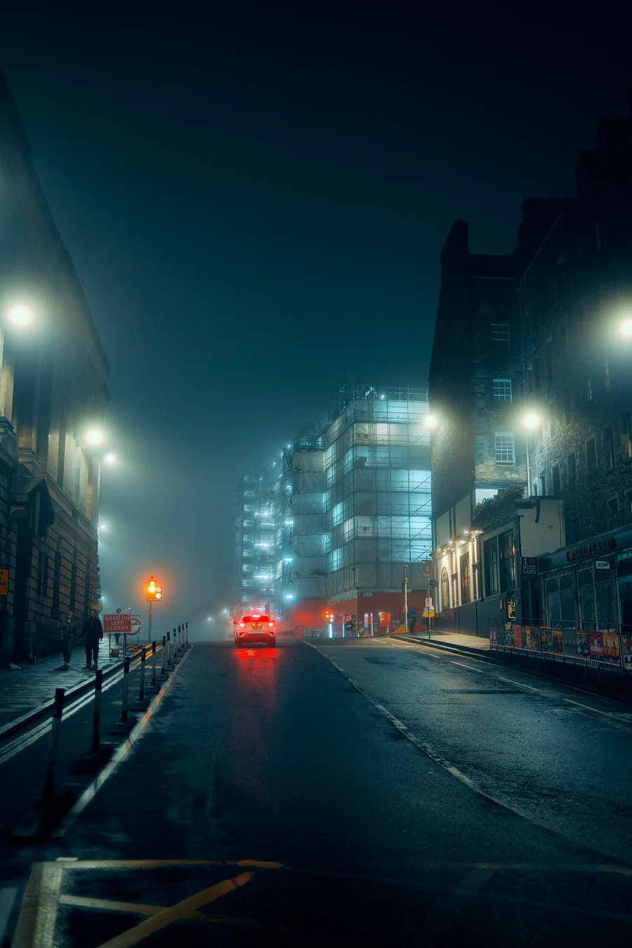 Car on a foggy city street at night